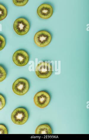 Les motifs des tranches de kiwi sur fond vert comme fond continu. Fond de fruit conceptuel texturé Banque D'Images