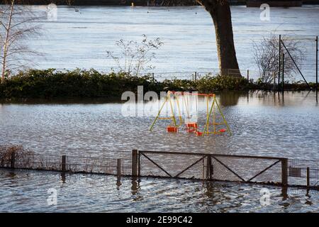 Inondation du Rhin à Cologne, terrain de jeu inondé, balançoires dans l'eau. Inondation Banque D'Images