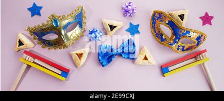 Fête de Purim. Hamantashen ou haman oreilles, le bruit et le masque sur fond gris. Vue de dessus Banque D'Images