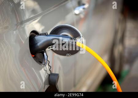 Frais de voiture électrique garés à côté d'un chargeur de véhicule électrique. Banque D'Images