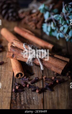 Sélection d'huiles essentielles avec bâtonnets de clou de girofle et de cannelle sur fond de bois. Banque D'Images