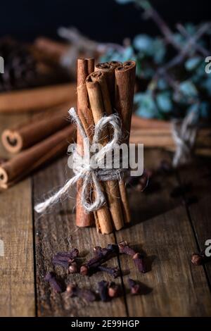 Sélection d'huiles essentielles avec bâtonnets de clou de girofle et de cannelle sur fond de bois. Banque D'Images