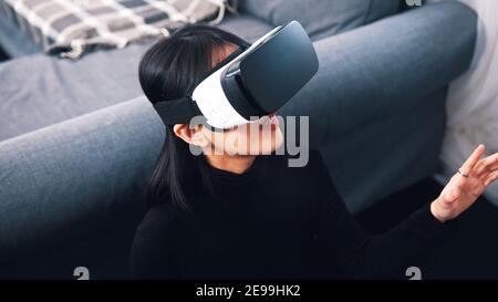 Femme asiatique excitée avec des lunettes VR qui vivent dans le monde virtuel. Photo de haute qualité Banque D'Images