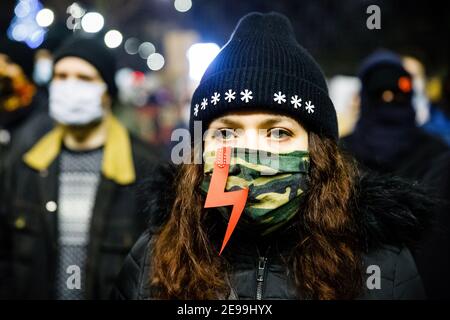 Un manifestant dans un masque militaire avec un éclairage rouge (symbole de la grève des femmes) pendant les manifestations.après le verdict de la Cour constitutionnelle polonaise qui est entré en vigueur le 27 janvier, pour mettre en œuvre l'une des lois anti-avortement les plus restrictives d'Europe, des centaines de Polonais ont pris les rues dans toutes les grandes villes. Des manifestations ont été organisées par la grève des femmes. Banque D'Images