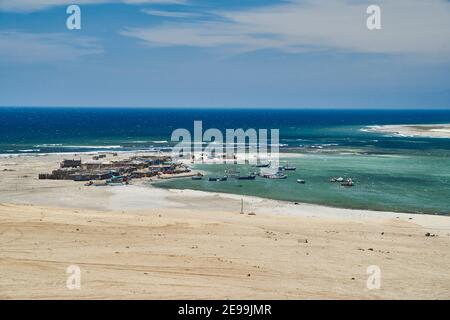 Village de pêcheurs dans le désert et vaste paysage de Paracas sur la côte du Pérou, un endroit était désert rencontre l'océan. Ciel bleu, nuages Banque D'Images