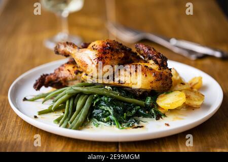 poussin rôti avec pommes de terre, chou-rafles, haricots verts et épinards crémeux Banque D'Images