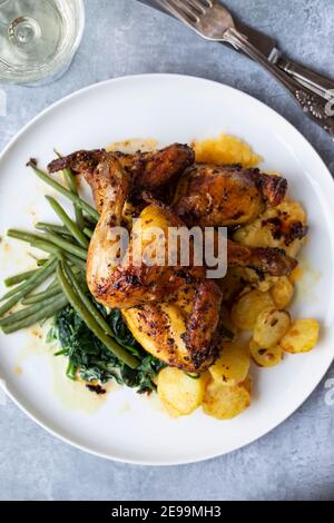 poussin rôti avec pommes de terre, chou-rafles, haricots verts et épinards crémeux Banque D'Images