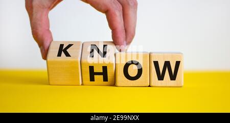 Symbole savoir-faire. Homme d'affaires transforme les cubes et le mot « comment » en « savoir ». Belle table jaune, fond blanc. Copier l'espace. Affaires et savoir Banque D'Images