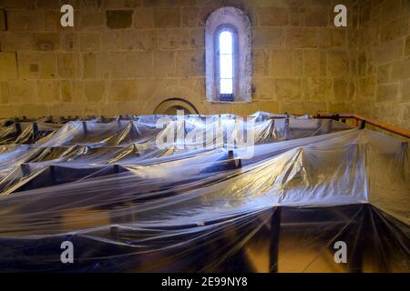 03 février 2021, Saxe-Anhalt, Quedlinburg : une bâche en plastique protège les chaises de la collégiale Saint-Servatii de la poussière. Le treillis de toit de la collégiale est actuellement en cours de rénovation, c'est pourquoi l'église est entourée d'échafaudages à l'intérieur et à l'extérieur. Ces travaux de rénovation devraient être terminés d'ici la mi-2022. Cette opération sera suivie par la rénovation de l'allée latérale qui devrait durer jusqu'à la fin de 2022. Malgré l'échafaudage à l'intérieur et à l'extérieur de l'église, le lieu de culte est ouvert à la prière. Les services paroissiaux ont lieu, mais pas dans la collégiale Banque D'Images