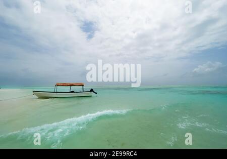 L'atoll peu profond les bancs de sable turquoise vagues avec le bateau de plaisance solitaire autour de l'île de Mnemba dans l'océan Indien près de l'île de Zanzibar, Tanzanie. Exotique Banque D'Images