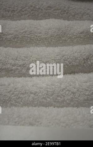 Gros plan texture rugueuse du tissu d'une pile de serviettes propres, blanches et soigneusement pliées. Banque D'Images