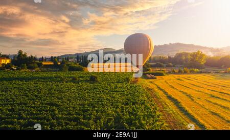 Photographie aérienne : montgolfière survolant les magnifiques champs et la plantation avec des montagnes en arrière-plan Banque D'Images