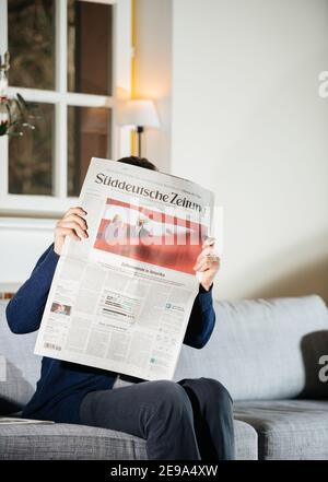 Paris, France - 21 janvier 2021 : une femme lisant le journal Suddeutsche Zeitung avec le président américain nouvellement élu a prêté serment en tant que 46e président des États-Unis Joe Biden et la première dame Jill Bide portant des masques Banque D'Images