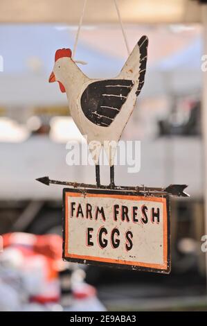 Ferme des œufs frais accrochant le panneau de poule de poulet sous une tente de stand de marché à un marché de fermiers en plein air à Santa Barbara, Californie, États-Unis Banque D'Images