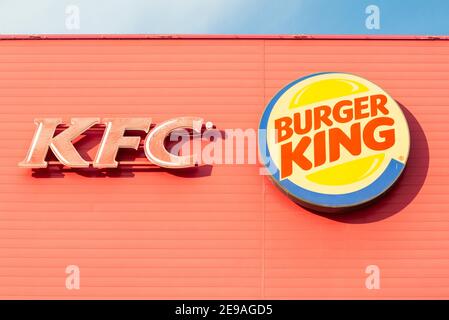 Les logos KFC et Burger King se sont côte à côte sur une façade murale rouge. Banque D'Images