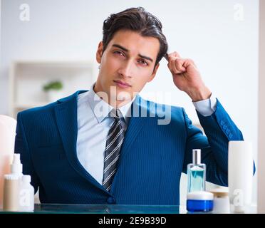 L'homme est en train de s'habiller pour aller au travail, dans la salle de bains Banque D'Images