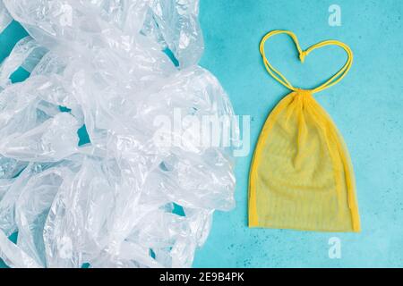 Sac jaune réutilisable en maille sous forme de coeur vs beaucoup de sacs en plastique. Concept ECO. Aucun gaspillage Banque D'Images