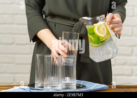femme versant de l'eau infusée de fruits du verre jag au verre, boissons, régime, concept de détox Banque D'Images