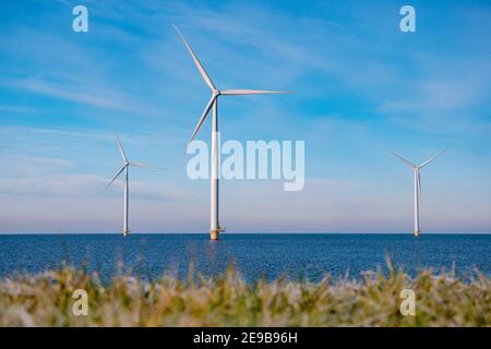 parc de moulins à vent en mer avec nuages orageux et un ciel bleu, parc de moulins à vent dans l'océan. Pays-Bas . Europe, turbines éoliennes dans l'océan avec ciel bleu, concept d'énergie verte Banque D'Images