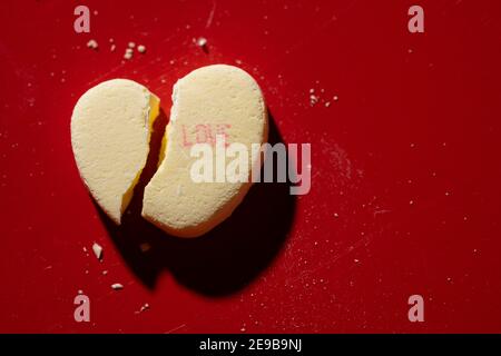 Un cœur de conversation de bonbons cassé avec « Love » imprimé dessus Banque D'Images