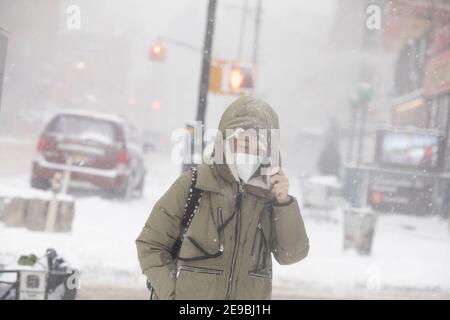 Une jeune femme qui marche sur la 7e avenue dans une tempête de neige Banque D'Images