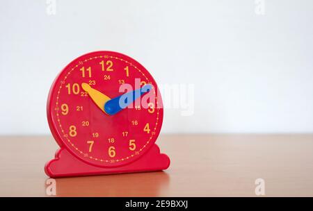 Horloge rouge dans une école primaire - apprendre comment les enfants pour indiquer l'heure sur l'horloge Banque D'Images