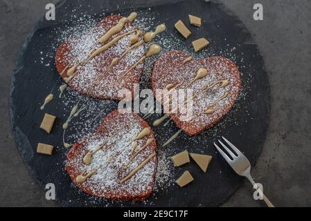 crêpes en velours rouge en forme de coeur sur une table Banque D'Images