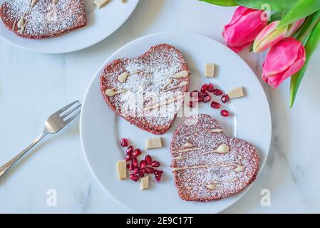 crêpes en velours rouge en forme de coeur sur une table Banque D'Images