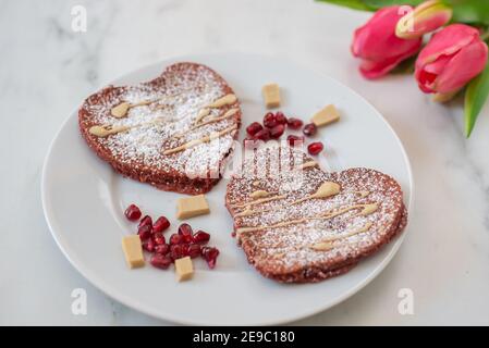 crêpes en velours rouge en forme de coeur sur une table Banque D'Images