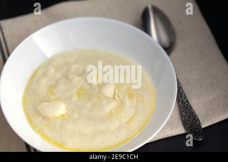 lait boudin chaud ou semoule avec beurre et cuillère sur la table. Le petit déjeuner est prêt Banque D'Images