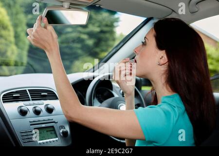 Woman putting on composent dans sa voiture Banque D'Images