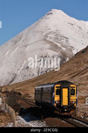 Le premier service de Glasgow à Mallaig de la journée monte au sommet de mars du comté, juste au nord de Tyndrum, sous une neige couverte Beinn Dorain. Banque D'Images