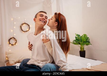 Un jeune couple amoureux dans un studio photo. Décor de Noël, gars et fille aiment les uns les autres. Poser pour des modèles en studio le réveillon du nouvel an. Adolescent Banque D'Images