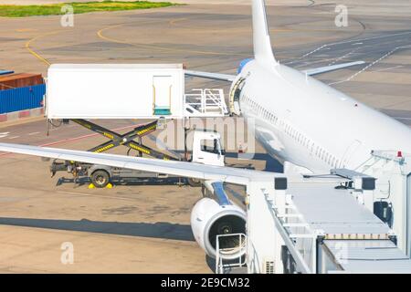 Chariot jaune à côté d'un avion passager, service avant vol de l'aéroport Banque D'Images