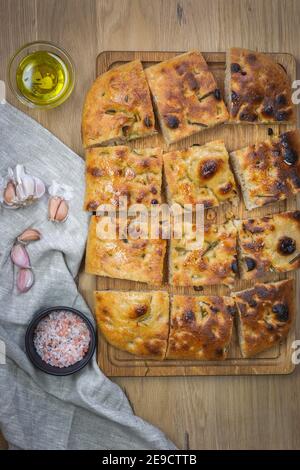 Focaccia traditionnelle de pain de levain naturel avec romarin et ail. Focaccia de grain entier sur un fond en bois. Artisan Banque D'Images