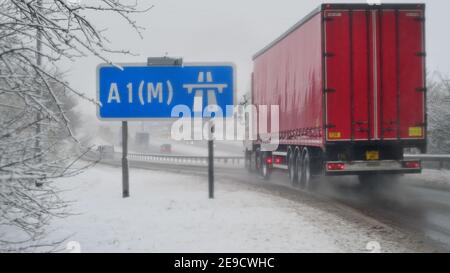 Camion passant le panneau de l'autoroute A1M dans la neige d'hiver Leeds Yorkshire Royaume-Uni Banque D'Images