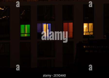 Time-lapse nocturne de lumières colorées dans les fenêtres d'un bâtiment à plusieurs étages. la vie dans une grande ville Banque D'Images