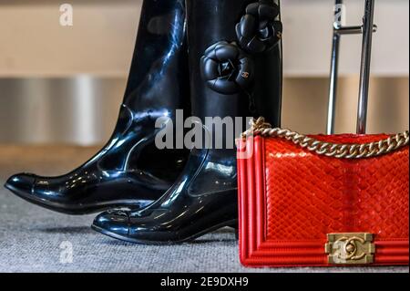 Londres, Royaume-Uni. 4 février 2021. Bottes Wellington design de Chanel avec design Camellia (partie d'un ensemble de 2 paires) est de £200-300 avec un sac de garçon moyen Python rouge, Chanel, c. 2014, est £2,000 - 3,000 - Aperçu de la collection Bonhams The Chanel: Vente aux enchères en ligne dédiée à la maison de mode française de luxe et offrant plus de 200 pièces allant des vêtements et accessoires aux sacs à main et bijoux à Bonhams Knightsbridge. La vente sera une vente aux enchères en ligne chronométrée de 11 jours du 5 au 16 février inclus. Crédit : Guy Bell/Alay Live News Banque D'Images