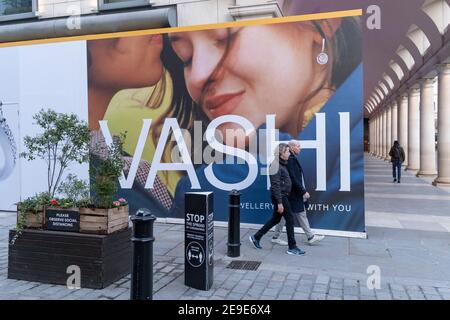 Un panneau d'affichage pour le détaillant de bijoux Vashi couvre leur extérieur de Covent Garden, derrière des panneaux exhortant les Londoniens à observer les règles de distance sociale de Covid pendant le troisième confinement de la pandémie du coronavirus, le 2 février 2021, à Londres, en Angleterre. Banque D'Images