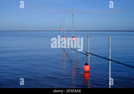 poteaux d'échafaudage et bouées rouges en mer, puits-à-côté-de-la-mer, nord de norfolk, angleterre Banque D'Images