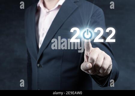 Homme d'affaires pressant 2022 start-up affaires. Appuyez sur le bouton de démarrage. L'objectif des affaires et de la technologie a fixé des objectifs et des réalisations en 2022, nouvelle année Banque D'Images