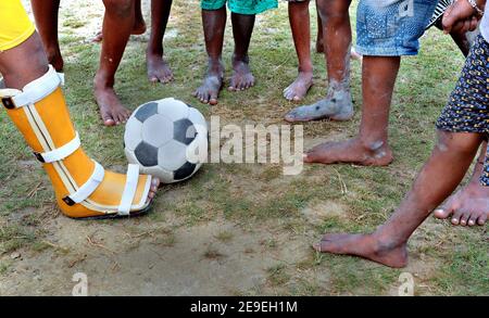 Les enfants isolés du village jouent au football dans le terrain de jeu du Bengale occidental en Inde. Banque D'Images