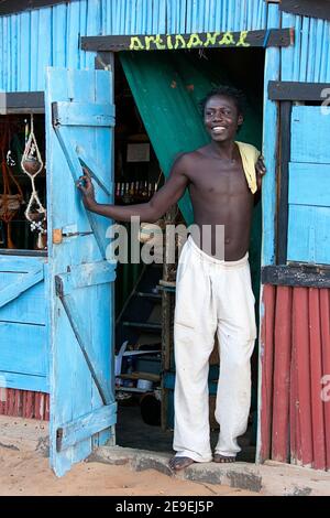 Pêcheur souriant à l'entrée de la hutte en bois bleu dans le petit village traditionnel de ramena au nord de Madagascar Banque D'Images