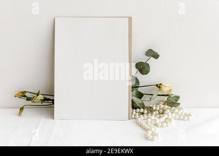 Papier à la mode papier à lettres fond - carte blanche pour lettrage et sécher les plantes et les fleurs sur une table blanche. Mariage d'arrière-plan féminin. Vide pour Banque D'Images