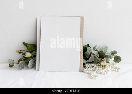 Papier à la mode papier à lettres fond - carte blanche pour lettrage et sécher les plantes et les fleurs sur une table blanche. Mariage d'arrière-plan féminin. Vide pour Banque D'Images