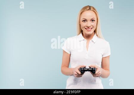 KIEV, UKRAINE - 25 NOVEMBRE 2020: Femme heureuse tenant le joystick isolé sur bleu Banque D'Images