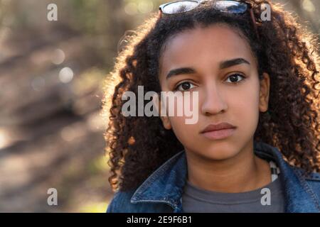 Portrait extérieur de la belle race mixte heureuse fille afro-américaine adolescente enfant qui a l'air pensive ou triste Banque D'Images