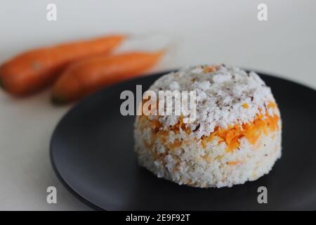 Puttu de carottes. Une variété de gâteau à la vapeur de riz Kerala en ajoutant des carottes râpées avec de la farine de riz et un mélange de noix de coco râpée Banque D'Images