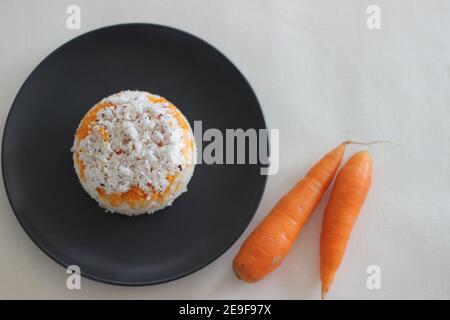 Puttu de carottes. Une variété de gâteau à la vapeur de riz Kerala en ajoutant des carottes râpées avec de la farine de riz et un mélange de noix de coco râpée Banque D'Images