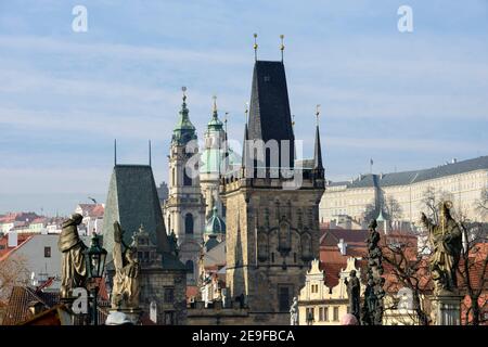 Vue panoramique depuis le pont Charles vers les petites tours de la ville, la cathédrale Saint-Nicolas et le château de Prague avec de nombreuses statues en premier plan, République tchèque. Banque D'Images